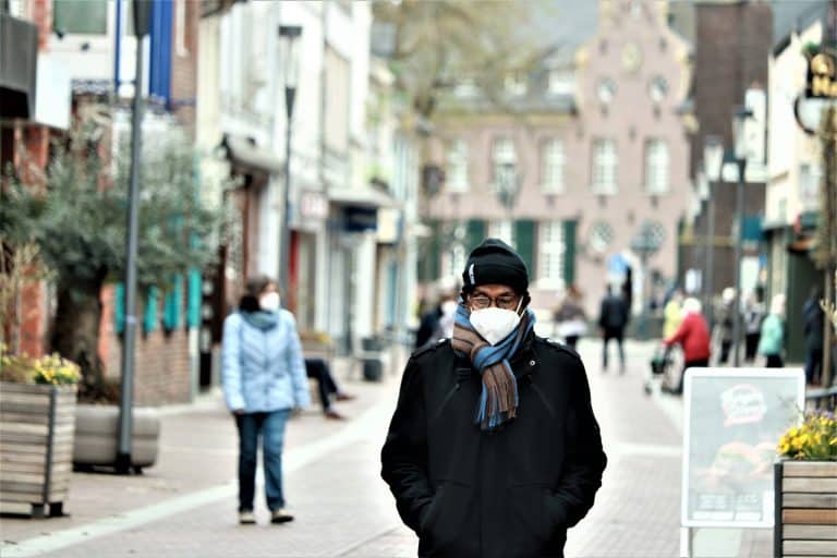 Man walking in a street wearing a face mask