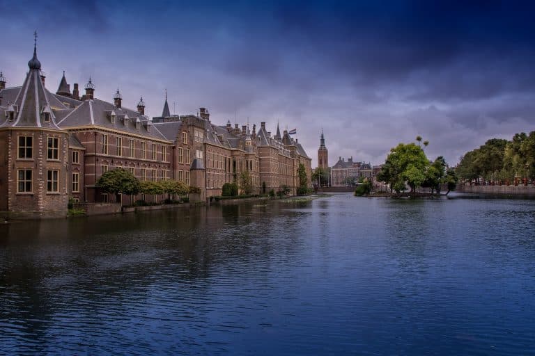 A pont with Ducth government buildings in the back and dark clouds in the sky. The Hague.